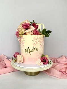 Tall pink and ivory gradient cake for a 70th birthday with fresh roses, macarons, and a gold Mum topper. Tall pink and ivory gradient cake for a 70th birthday with fresh roses, macarons, and a gold Mum topper.