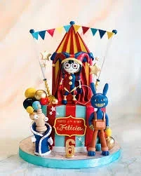 Amazing Digital Circus themed cake featuring Pomni, Jax, and Kinger figures with a circus tent backdrop and colorful bunting. Amazing Digital Circus themed cake featuring Pomni, Jax, and Kinger figures with a circus tent backdrop and colorful bunting.