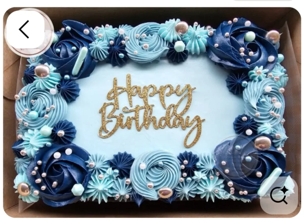 Light blue rectangular birthday cake with navy and light blue icing rosettes, silver dragees, and a gold glitter Happy Birthday topper. Light blue rectangular birthday cake with navy and light blue icing rosettes, silver dragees, and a gold glitter Happy Birthday topper.