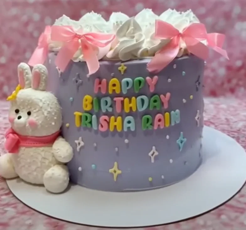 Purple single tier birthday cake for Trisha Rain featuring a large white fondant bunny and pink satin bows. Purple single tier birthday cake for Trisha Rain featuring a large white fondant bunny and pink satin bows.