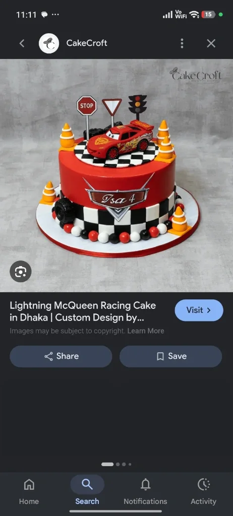Cars-Inspired Theme Cake Red fondant cake with a Lightning McQueen car topper, traffic signs, orange cones, and a checkered racing pattern