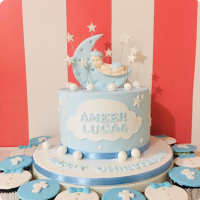 Light blue fondant cake with a sleeping baby on a crescent moon topper, white clouds, and stars for a christening celebration. Light blue fondant cake with a sleeping baby on a crescent moon topper, white clouds, and stars for a christening celebration.