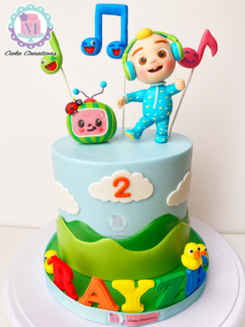 Cocomelon themed 1-tier light blue fondant cake with JJ figure, music notes, and a watermelon TV topper. Cocomelon themed 1-tier light blue fondant cake with JJ figure, music notes, and a watermelon TV topper.