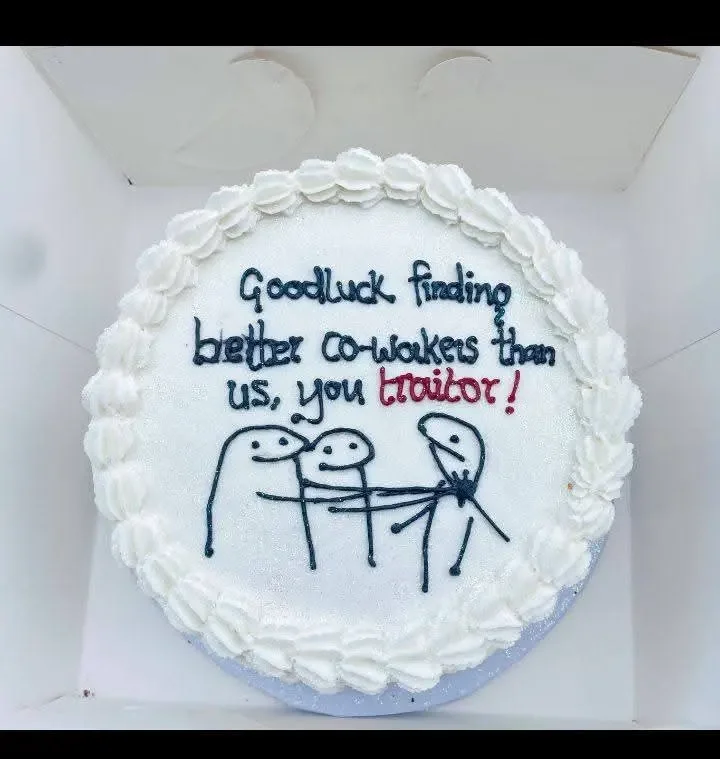 White minimalist bento-style cake with a humorous message and hand-drawn flork characters in black icing. White minimalist bento-style cake with a humorous message and hand-drawn flork characters in black icing.