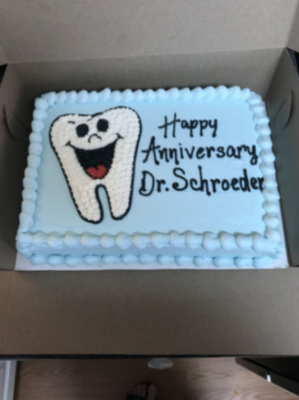 Dental Anniversary Sky Blue Rectangle Cake Light blue rectangle cake with smooth soft icing, a molded tooth topper, and piped shell borders
