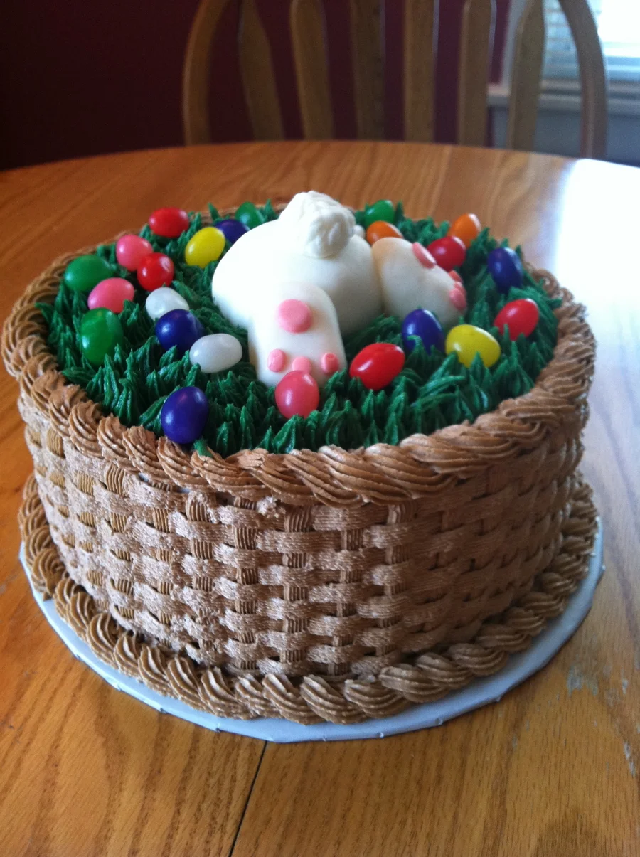 Easter basket cake with brown basketweave icing, green grass piping, a white fondant bunny butt, and colorful jelly bean eggs. Easter basket cake with brown basketweave icing, green grass piping, a white fondant bunny butt, and colorful jelly bean eggs.