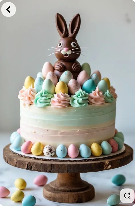 A pastel-colored Easter cake featuring a large chocolate bunny topper surrounded by colorful speckled eggs and soft icing swirls. A pastel-colored Easter cake featuring a large chocolate bunny topper surrounded by colorful speckled eggs and soft icing swirls.