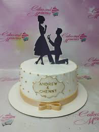 White 1-tier engagement cake with gold accents, a black silhouette couple topper, and a gold-bordered name plaque. White 1-tier engagement cake with gold accents, a black silhouette couple topper, and a gold-bordered name plaque.