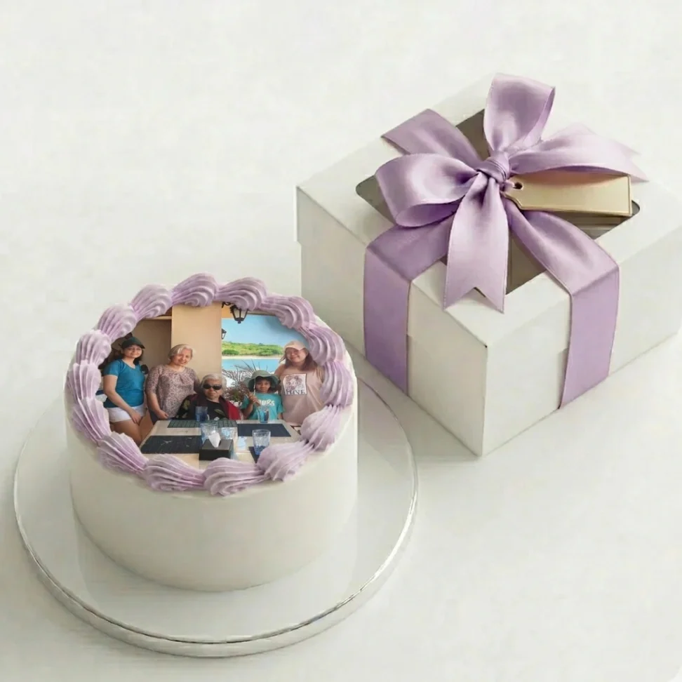 A minimalist white round cake featuring a large edible photo print of a family on top, bordered by lavender icing rosettes. A minimalist white round cake featuring a large edible photo print of a family on top, bordered by lavender icing rosettes.
