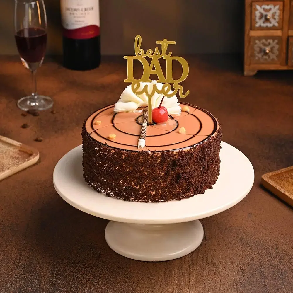 Chocolate cake with dark chocolate shavings on the side, topped with a gold 'Best Dad Ever' cardstock topper and a cherry. Chocolate cake with dark chocolate shavings on the side, topped with a gold 'Best Dad Ever' cardstock topper and a cherry.