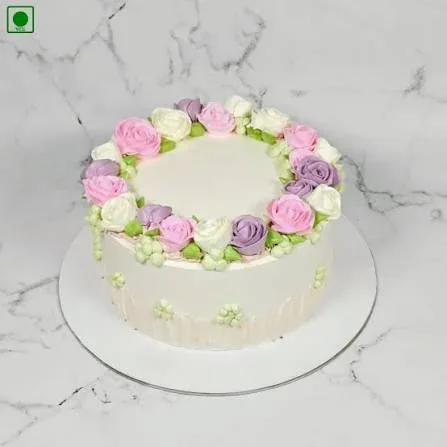 Floral White Cake White 1-tier cake with smooth soft icing, piped floral wreath, and small green icing clusters