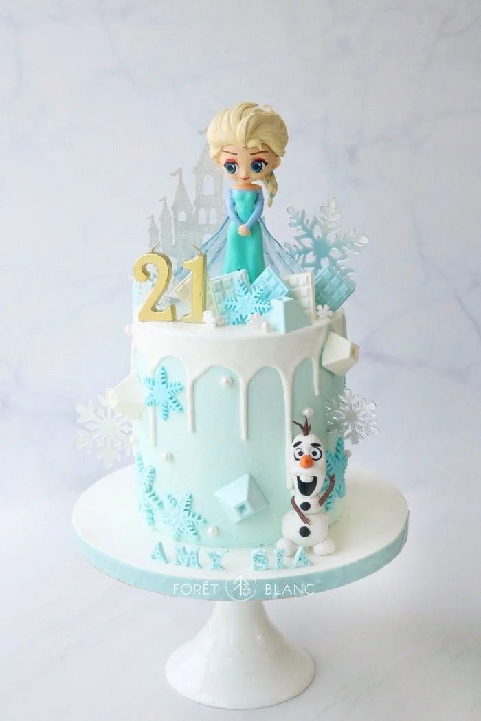 Frozen-Inspired Sky Blue Drip Birthday Cake Light blue 1-tier cake with white drip, Elsa and Olaf figurines, gold 21 candle, and snowflake decorations