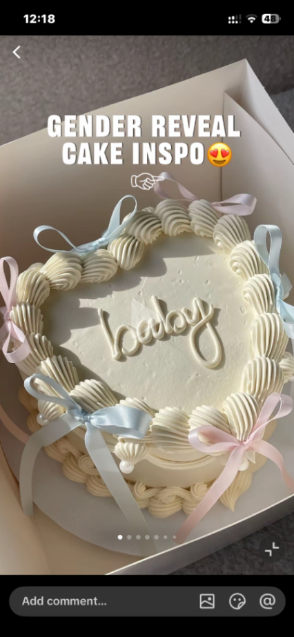 Heart-shaped white minimalist gender reveal cake with pink and blue satin ribbons and piped icing borders. Heart-shaped white minimalist gender reveal cake with pink and blue satin ribbons and piped icing borders.