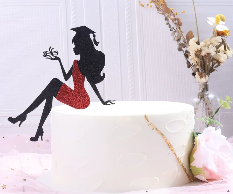 White minimalist graduation cake with a black and red glittery silhouette topper of a graduate holding a diploma and a gold leaf accent. White minimalist graduation cake with a black and red glittery silhouette topper of a graduate holding a diploma and a gold leaf accent.