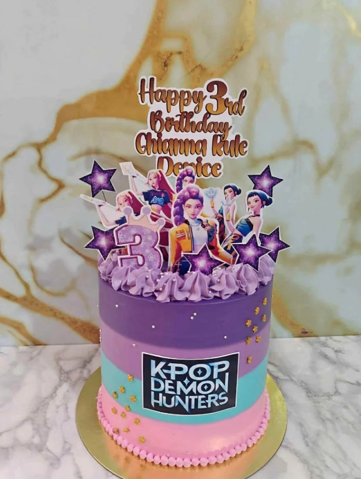 K-Pop Demon Hunters themed birthday cake with purple, teal, and pink gradient icing and character printouts. K-Pop Demon Hunters themed birthday cake with purple, teal, and pink gradient icing and character printouts.