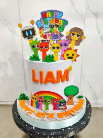 White textured 1-tier birthday cake for Liam featuring colorful cartoon character printouts, a rainbow, and orange gumpaste letters. White textured 1-tier birthday cake for Liam featuring colorful cartoon character printouts, a rainbow, and orange gumpaste letters.