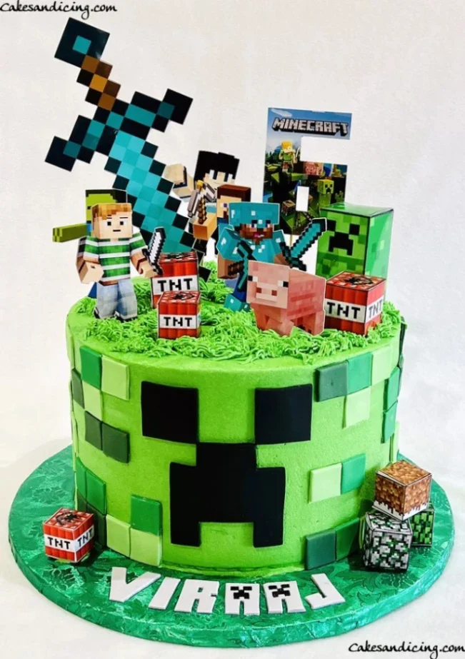 Green Minecraft Creeper cake with TNT blocks, Steve, Alex, and a pixelated sword topper on a green grass-textured top.