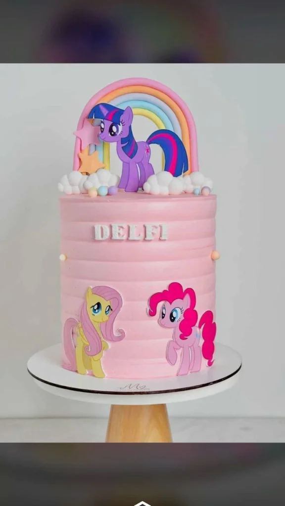 Tall pink My Little Pony themed cake with Twilight Sparkle, Fluttershy, and Pinkie Pie printouts, a fondant rainbow, and white clouds. Tall pink My Little Pony themed cake with Twilight Sparkle, Fluttershy, and Pinkie Pie printouts, a fondant rainbow, and white clouds.
