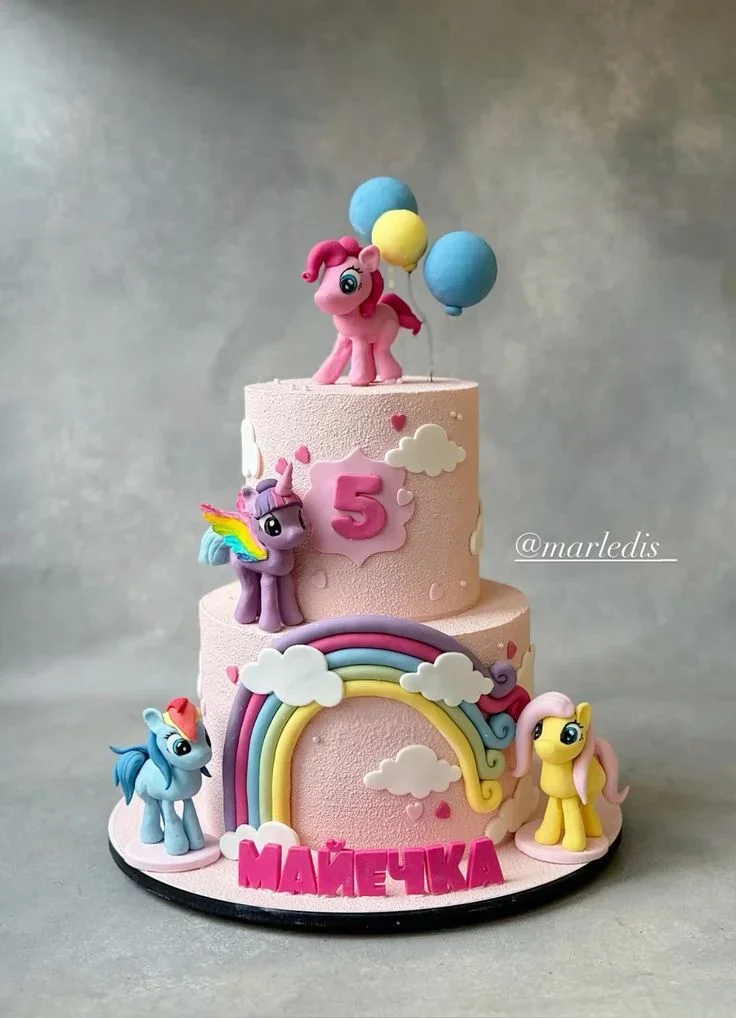 Pink 2-tier My Little Pony themed cake with 3D fondant pony figures, a large rainbow, and clouds. Pink 2-tier My Little Pony themed cake with 3D fondant pony figures, a large rainbow, and clouds.