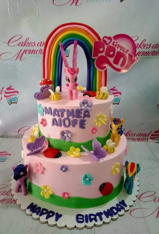 Pink 2-tier My Little Pony birthday cake with a large fondant rainbow, character printouts, and colorful gumpaste flowers and butterflies. Pink 2-tier My Little Pony birthday cake with a large fondant rainbow, character printouts, and colorful gumpaste flowers and butterflies.