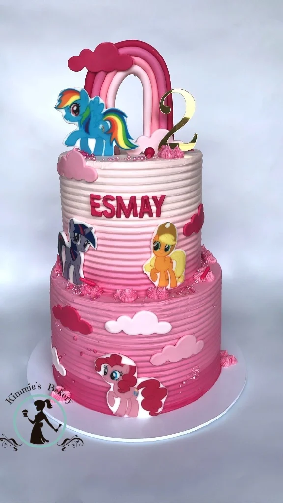 Two-tier pink ombre My Little Pony birthday cake with a fondant rainbow, gold number 2 topper, and character cutouts of Rainbow Dash and Pinkie Pie. Two-tier pink ombre My Little Pony birthday cake with a fondant rainbow, gold number 2 topper, and character cutouts of Rainbow Dash and Pinkie Pie.