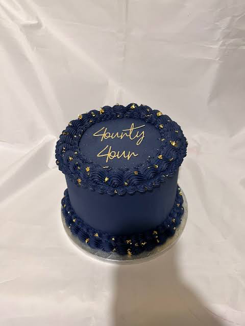 Navy blue minimalist cake with gold leaf accents and a gold Forty Four topper. Navy blue minimalist cake with gold leaf accents and a gold Forty Four topper.
