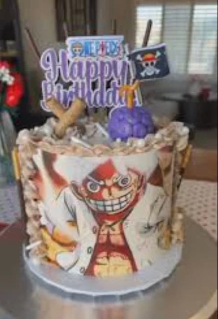 One Piece themed birthday cake with Luffy Gear 5 printout, purple devil fruit topper, and chocolate sticks. One Piece themed birthday cake with Luffy Gear 5 printout, purple devil fruit topper, and chocolate sticks.