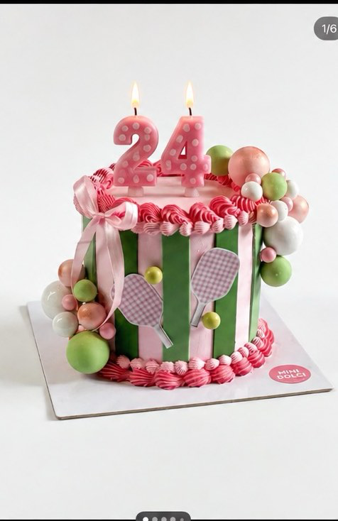 Pickleball Birthday Cake Pink 1-tier cake with soft icing finish, pickleball racket printouts, and a pink satin ribbon bow