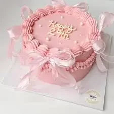 Monochromatic pink minimalist cake with piped icing borders, white pearls, and pink satin bows featuring a Happy 29th message.