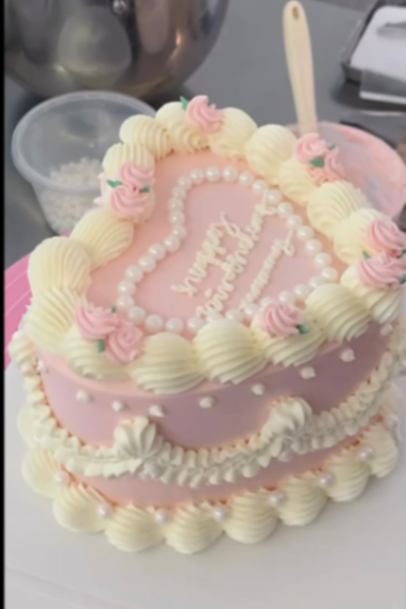 Heart-shaped pink vintage cake with white icing ruffles, pink rosettes, and edible pearls. Heart-shaped pink vintage cake with white icing ruffles, pink rosettes, and edible pearls.