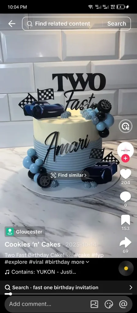 A two-tier style blue and white racing themed cake with Lightning McQueen printouts, checkered flags, and blue and black decorative balls. A two-tier style blue and white racing themed cake with Lightning McQueen printouts, checkered flags, and blue and black decorative balls.