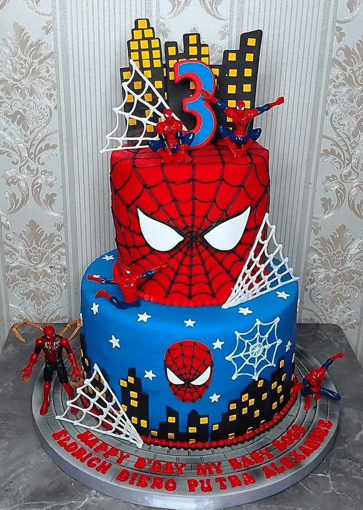 Spider Man 2-Tier Birthday Cake Red and blue 2-tier fondant Spiderman birthday cake with city skyline topper, action figures, and spider webs