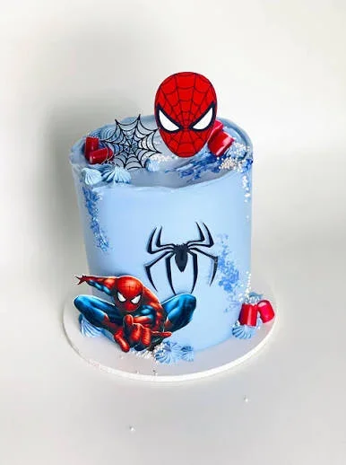 Spider Man Sky Blue Pearl Birthday Cake Light blue 1-tier soft icing cake with Spiderman printouts, spiderweb accents, and white pearl sprinkles