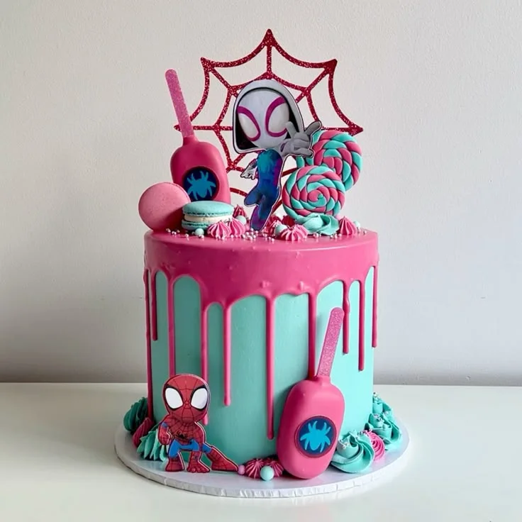 Spider Superhero Light Pink Drip Birthday Cake Light blue and pink 1 tier birthday cake with dark pink drip, spider hero printouts, lollipops, and popsicles