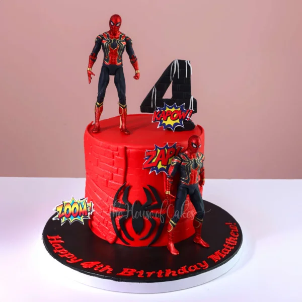 Spiderman-Inspired Birthday Cake Red fondant 1-tier birthday cake with Spiderman action figures, brick pattern panels, and comic printouts
