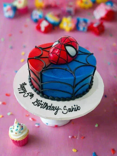 Spiderman-Inspired Birthday Cake Red and blue 1 tier soft icing birthday cake with a Spiderman mask topper and black spider webs