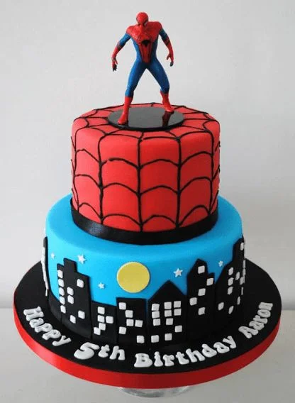 Spiderman-Inspired 2-Tier Cake Blue and red 2-tier fondant superhero cake with a Spiderman action figure, cityscape skyline, and moon