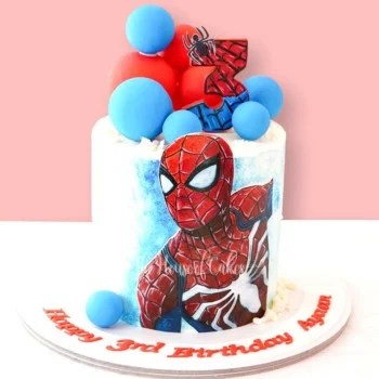Spiderman-Inspired White Birthday Cake White 1-tier soft icing birthday cake featuring a Spiderman character printout, number three topper, and blue and red spheres