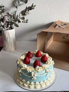 Strawberry Minimalist Sky Blue Cake Light blue 1-tier cake with soft icing, fresh strawberry toppers, and white piped borders