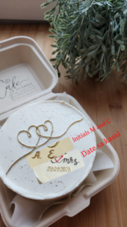 White bento cake with gold heart design and personalized wedding anniversary message in a clamshell box. White bento cake with gold heart design and personalized wedding anniversary message in a clamshell box.