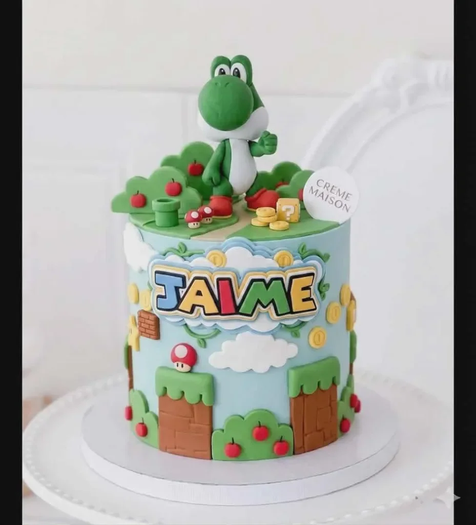 Light blue Yoshi Super Mario themed cake with 3D Yoshi figure, fondant trees, clouds, and Jaime nameplate.