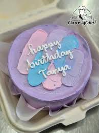 A photo of an Abstract Strokes themed cake. It is a Purple Bento cake decorated with abstract icing strokes in pink, blue, and purple, and the message 'happy birthday Tanya'. A photo of an Abstract Strokes themed cake. It is a Purple Bento cake decorated with abstract icing strokes in pink, blue, and purple, and the message 'happy birthday Tanya'.