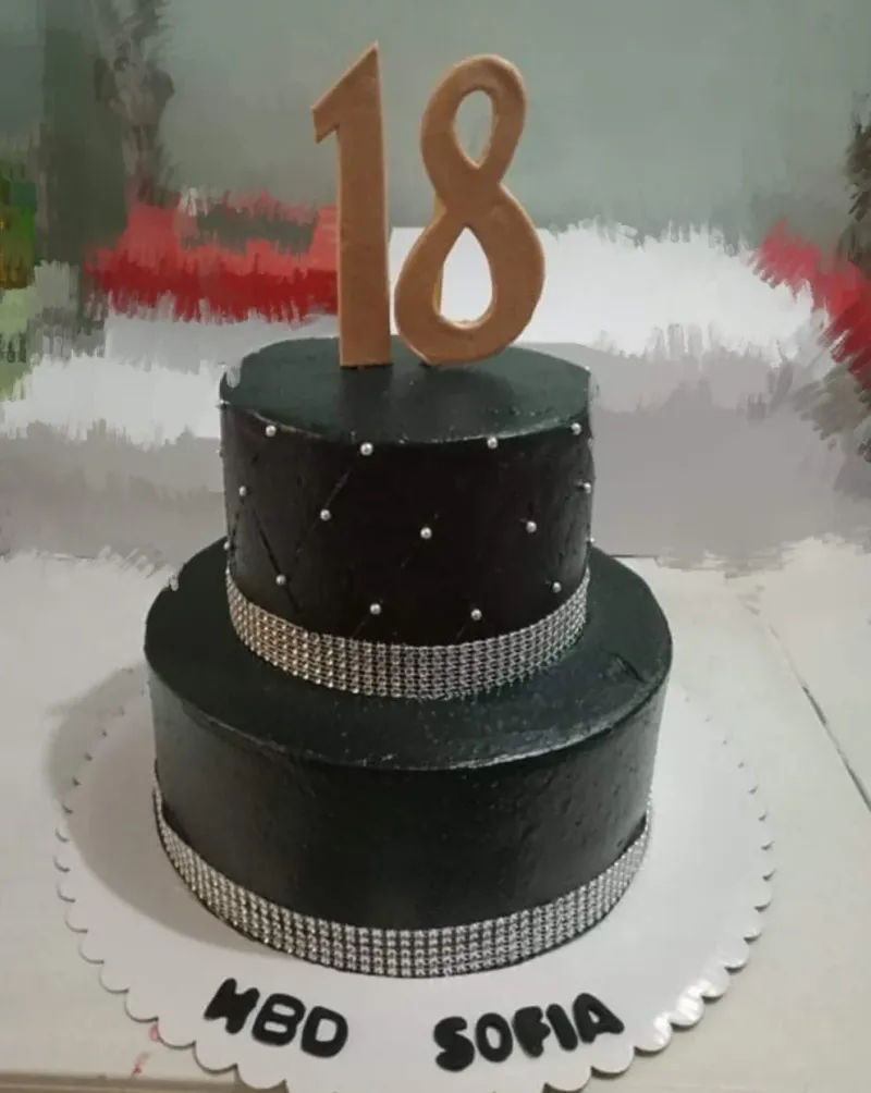 Elegant black 2-tier 18th birthday cake with silver quilted pattern, edible pearls, and large gold number 18 topper. Elegant black 2-tier 18th birthday cake with silver quilted pattern, edible pearls, and large gold number 18 topper.