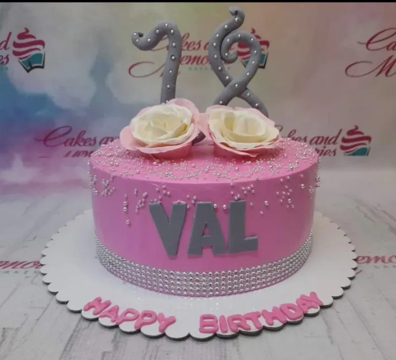 A pink and white 1 Tier cake themed around 18th Birthday, featuring a silver number 18 topper and white roses with silver beads. A pink and white 1 Tier cake themed around 18th Birthday, featuring a silver number 18 topper and white roses with silver beads.