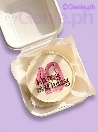 A white bento cake themed around 19th Birthday Minimalist, featuring a pink palette knife number 19 and a black piped happy birthday message. A white bento cake themed around 19th Birthday Minimalist, featuring a pink palette knife number 19 and a black piped happy birthday message.