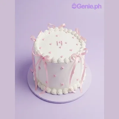 White 1-tier birthday cake with pink ribbons and small pink hearts White 1-tier birthday cake with pink ribbons and small pink hearts