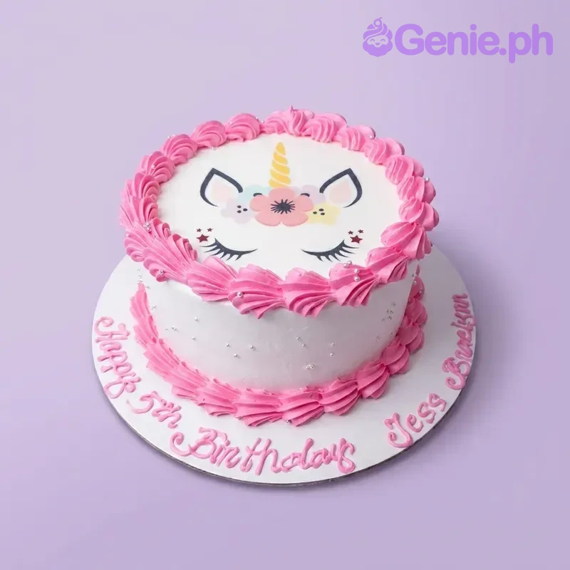Unicorn White Floral Birthday Cake A white and pink 1 Tier cake themed around Unicorns, featuring a printed unicorn face and pink icing rosettes with silver dragees.