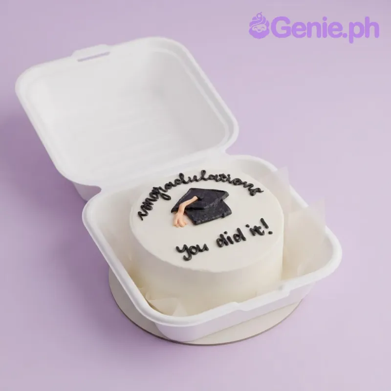 White bento cake with smooth icing, a black graduation cap topper, and black piped text reading Congratulations You did it White bento cake with smooth icing, a black graduation cap topper, and black piped text reading Congratulations You did it