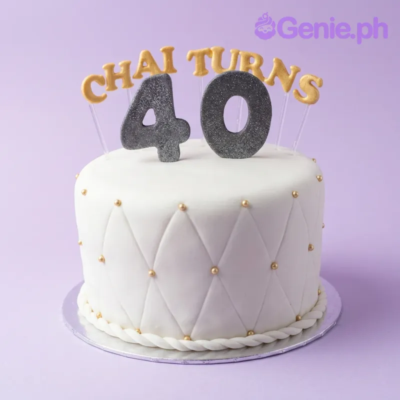 White fondant cake with quilted diamond pattern and gold pearls, topped with a glittery number 40 and Chai Turns message. White fondant cake with quilted diamond pattern and gold pearls, topped with a glittery number 40 and Chai Turns message.