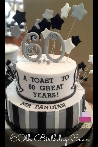 Two-tier black and white striped 60th birthday cake with silver and black fondant stars on wires and a large silver 60 topper. Two-tier black and white striped 60th birthday cake with silver and black fondant stars on wires and a large silver 60 topper.